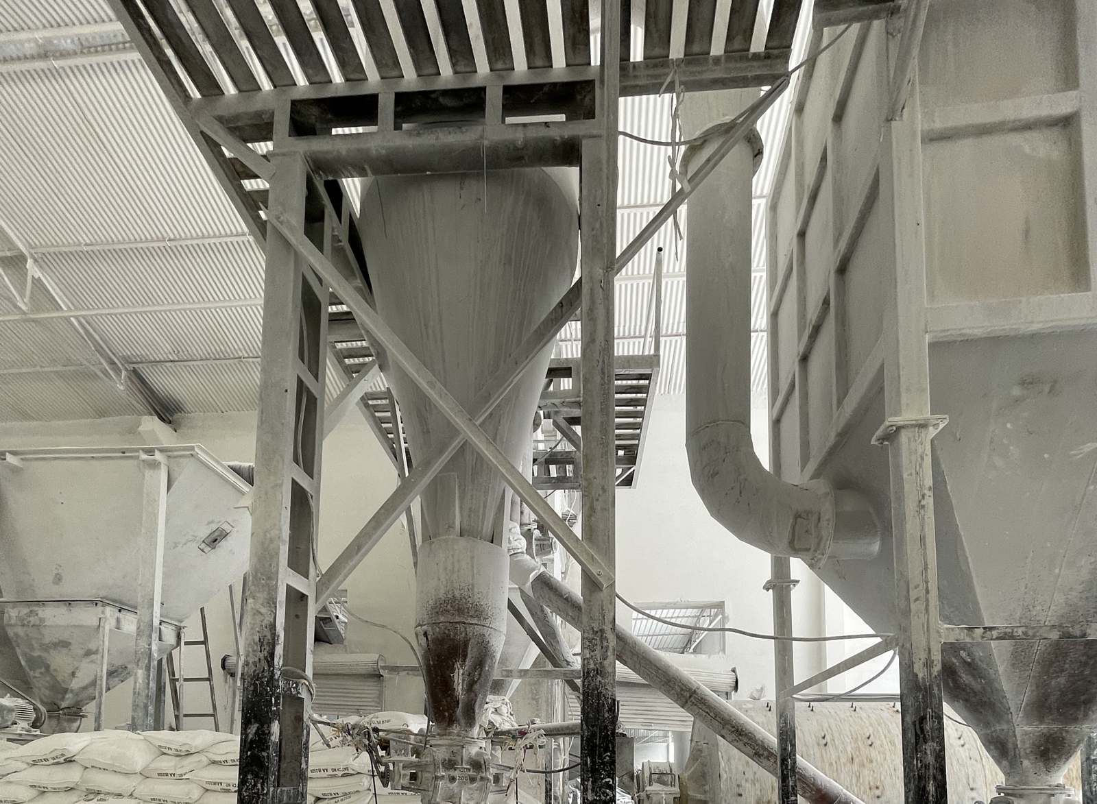 Hoppers and ducting above the bagging floor of a mineral processing shed