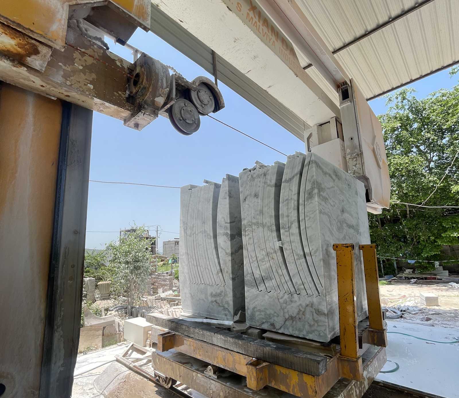 Stone block being cut into slabs on a wire saw