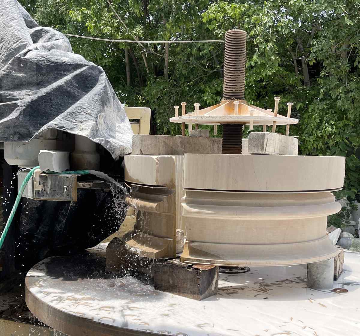 Stone column being turned on a lathe