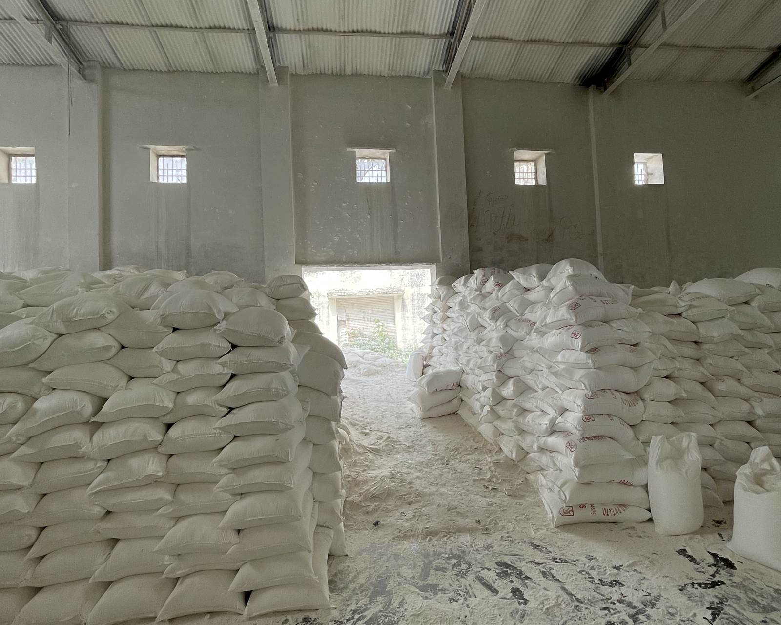 Talc powder bags stacked in rows inside a mineral warehouse