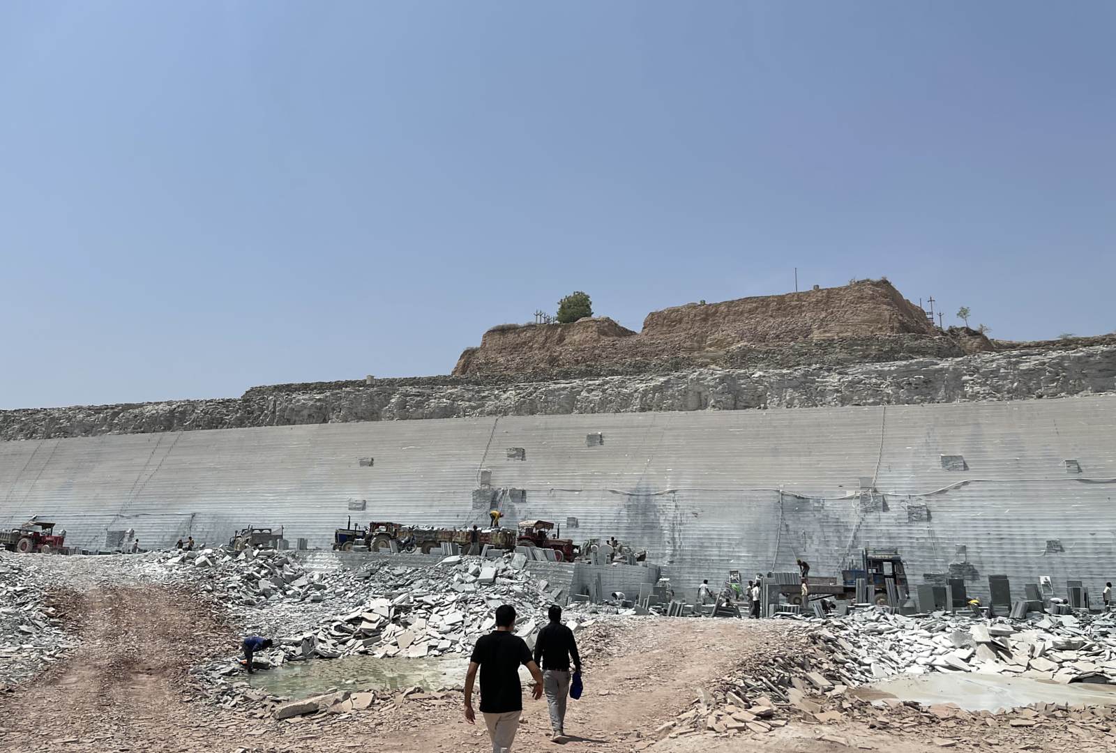 Two people walking towards a quarry face